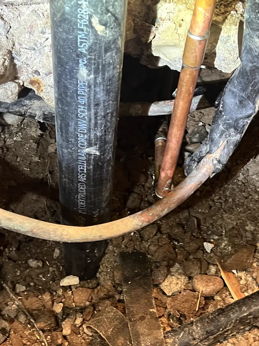 New copper supply line routed under the slab before the concrete is patched